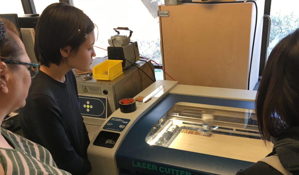 students watching the laser cutter